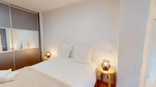 - une chambre blanche avec un lit blanc et deux lampes dans l'établissement Le Roesselmann 1 parking, à Colmar