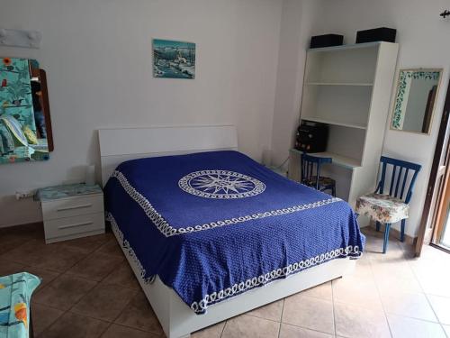 Un dormitorio con una cama con una manta azul. en Casa degli uccellini - Cerreto di Spoleto, en Cerreto di Spoleto