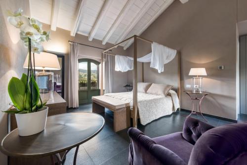 卡斯蒂廖內迪西奇利亞的住宿－Firriato Hospitality Cavanera Etnea Resort & Wine Experience，一间卧室配有一张床、一张桌子和一张沙发