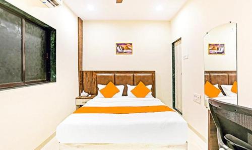 a bedroom with a bed with orange pillows and a sink at Tavakkal Hotel Near Bandra Kurla Mumbai in Mumbai