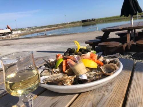 a plate of food on a table next to a glass of wine at Maison de Rêve in Notre-Dame-du-Touchet