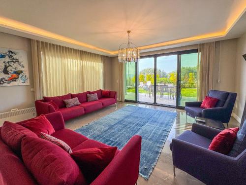 sala de estar con sofá rojo y sillas en Villa Elite en Kusadasi