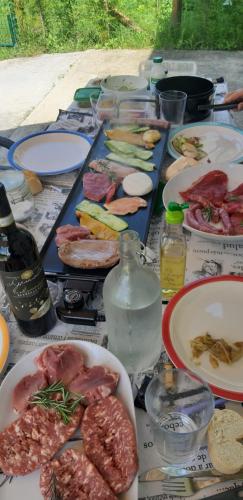 a table with plates of food and bottles of wine at CASCINA BINELLO appartamento B in Murazzano