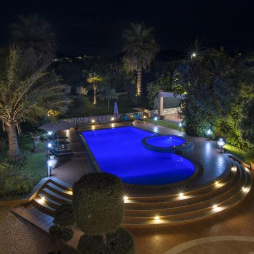 a swimming pool at night with lights around it at Villa Elina Luxury Residence in Stalos