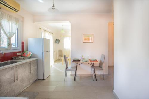 cocina con mesa y nevera blanca en Dimitra's Apartment en Nydri