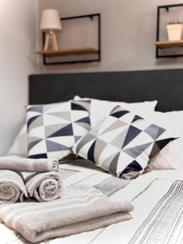 a bedroom with a bed with pillows and towels at FiloXenia by the Sea in Agios Nikolaos