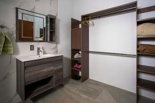 a bathroom with a sink and a refrigerator at New Family-Friendly Poolside Escape in Pazulco