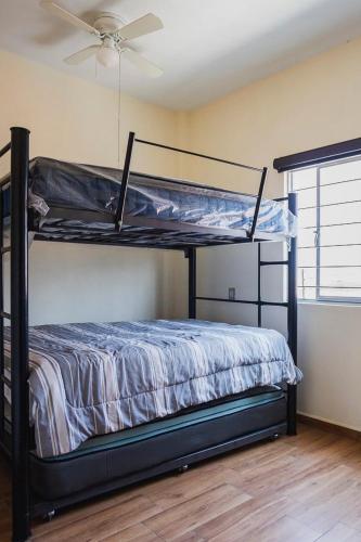 two bunk beds in a room with a ceiling fan at New Family-Friendly Poolside Escape in Pazulco