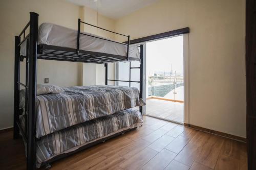 a bedroom with two bunk beds and a balcony at New Family-Friendly Poolside Escape in Pazulco