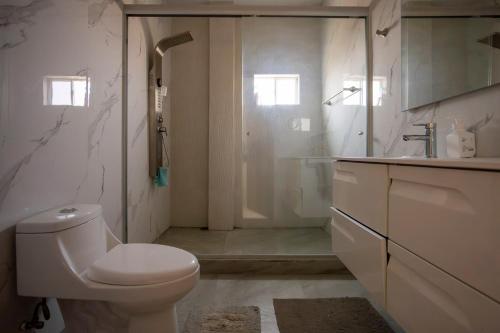 a bathroom with a toilet and a sink and a shower at New Family-Friendly Poolside Escape in Pazulco
