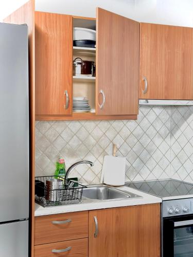 a kitchen with a sink and a refrigerator at FiloXenia by the Sea in Agios Nikolaos