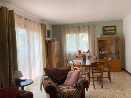 un salon avec une table et une salle à manger dans l'établissement Haut de villa avec terrasse privative jardin et parking tout près des plages, à Toulon