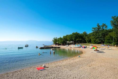 a group of people on a beach in the water at Krk Njivice in Njivice
