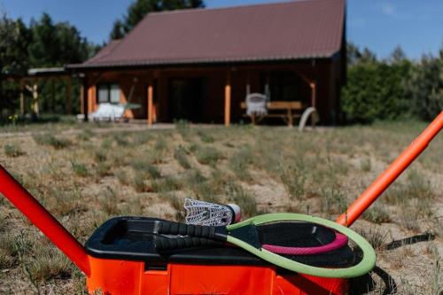 a pair of scissors sitting in a container in front of a house at Rodzinny Dom na Łonie Natury in Joniec