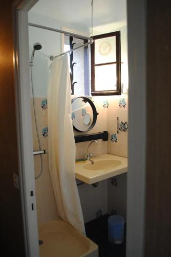 une petite salle de bain avec un lavabo et un miroir dans l'établissement Maison chaleureuse en Pays-de-Belvès avec terrasse et jardin, à Belvès