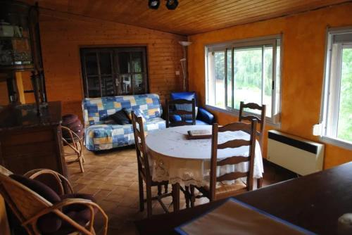 ein Wohnzimmer mit Tisch und Stühlen und einer Couch in der Unterkunft Maison chaleureuse en Pays-de-Belvès avec terrasse et jardin in Belvès