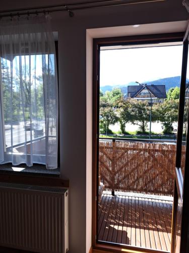 a door to a deck with a view of a house at Przy Szlaku Zakopane centrum pokoje & apartamenty in Zakopane