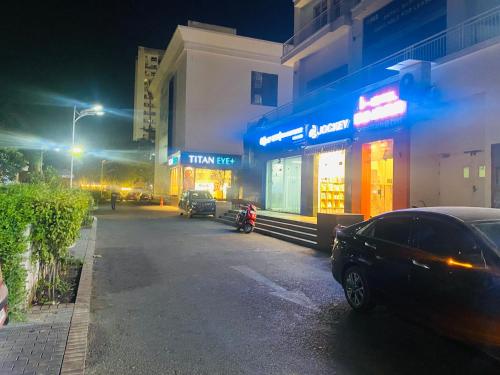 a street at night with cars parked in front of a store at DLF Royal Stay in Lucknow