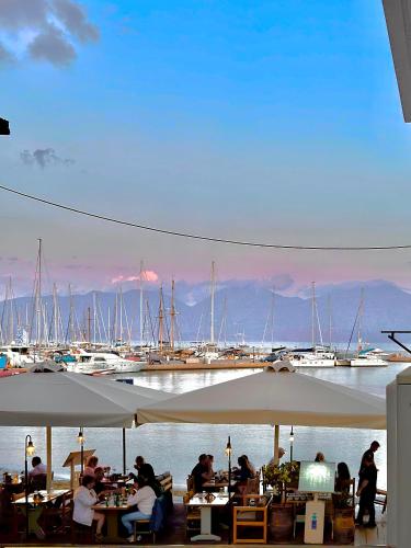 a group of people sitting at tables at a marina at FiloXenia by the Sea in Agios Nikolaos