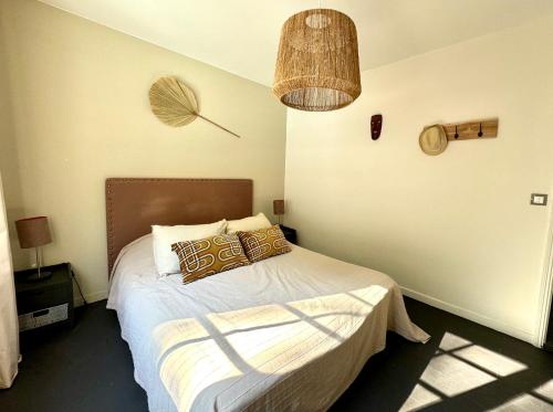 une chambre avec un lit avec des oreillers dessus dans l'établissement Sand Pedro, à Pyla-sur-Mer