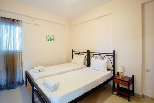 1 dormitorio con 2 camas, mesa y ventana en Dimitra's Apartment en Nydri