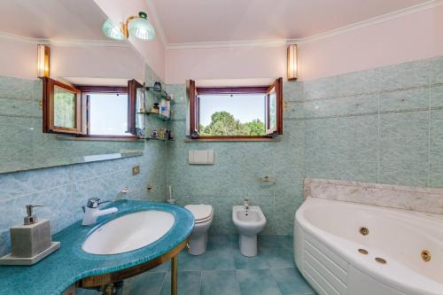 y baño con lavabo, bañera y aseo. en Villa Carolina - Piscina e Parco panoramico, en Campagnano di Roma