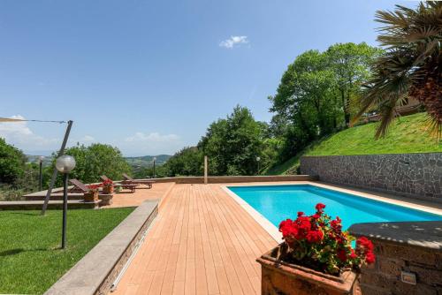 een zwembad met rode bloemen in een tuin bij Villa Carolina - Piscina e Parco panoramico in Campagnano di Roma