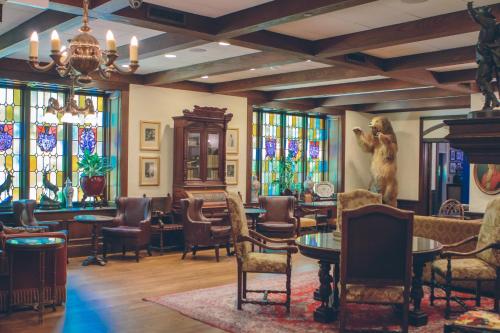a room with chairs and tables and stained glass windows at The Cheshire in Saint Louis