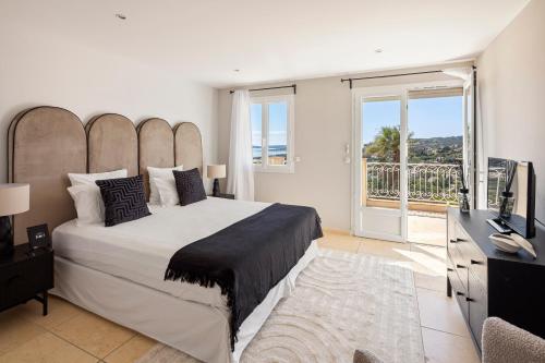 une chambre avec un grand lit et un balcon dans l'établissement Villas Raphaël, aux Issambres