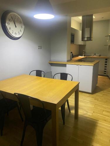 une cuisine avec une table et une horloge au mur dans l'établissement Quartier Mouffetard, à Paris