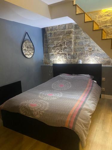 une chambre avec un lit avec un mur en pierre dans l'établissement Quartier Mouffetard, à Paris