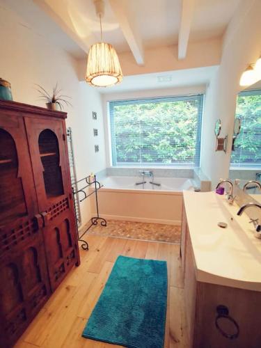 une salle de bain avec une baignoire et un lavabo et une baignoire dans l'établissement Grande maison bois entre océan et lac, à Vielle-Saint-Girons