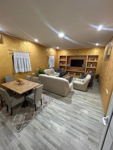 a living room with couches and a table and a television at Kristina House in Opornica