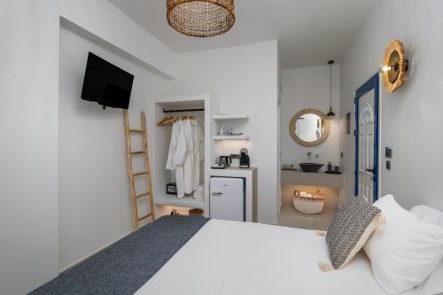 a bedroom with a white bed and a bathroom at Pergola in Pollonia