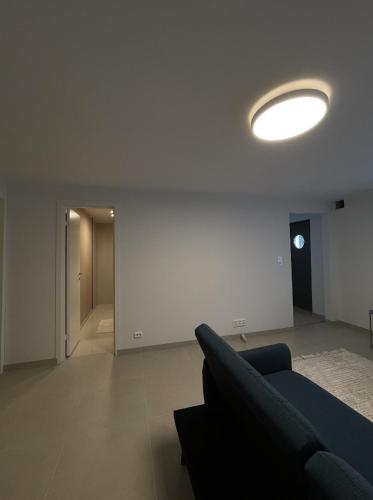 a living room with a blue couch and a white wall at Central leilighet i Kristiansand - Hellemyr in Kristiansand