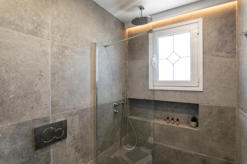 a bathroom with a shower with a window at Pergola in Pollonia