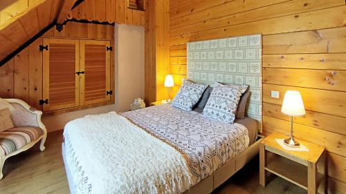 une chambre avec un lit et un mur en bois dans l'établissement Gîte chalet la Bergerie de Sentantony - Val d'Azun - Montagne Pyrénées, à Bun