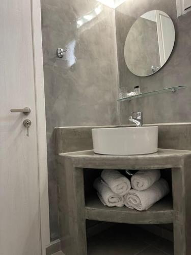 a bathroom with a sink and a pile of towels at Sklavadi Vineyard House in Kamari