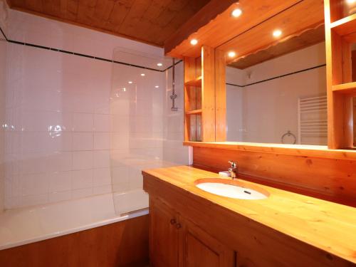 une salle de bain avec un lavabo, une baignoire et un miroir dans l'établissement Charmant 2 pièces avec balcon et Wi-Fi à Méribel, classé 3* pour 4 personnes - FR-1-182-25, à Méribel
