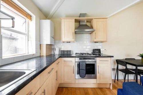 a kitchen with a sink and a stove top oven at Lovely 3-bed 20 minutes to Central London in London