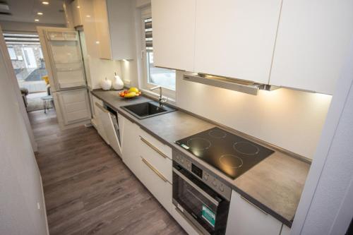 uma cozinha com armários brancos e um forno com placa de fogão em Seepark Cox em Goch