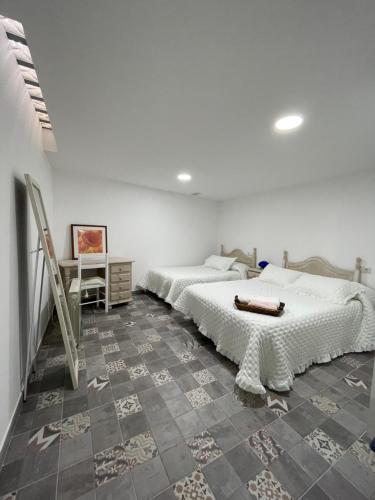 1 Schlafzimmer mit 2 Betten und Fliesenboden in der Unterkunft El rincón coqueto de fina in Orce