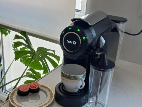 una macchina per il caffè appoggiata su un bancone con un cupcake di Apartament ANNA a Biała Podlaska