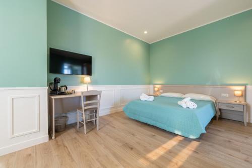 a bedroom with a bed and a desk and a television at Daca luxury rooms in Naples