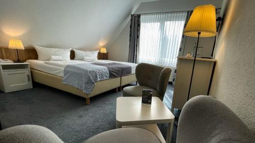 a hotel room with a bed and a table and chairs at Hotel & Restaurant Seebrücke in Zingst