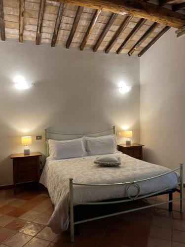 a bedroom with a bed with two lamps on two tables at Agriturismo Le Querciole in Val d'Orcia in Bagno Vignoni