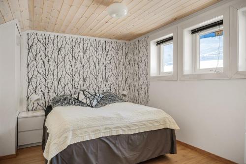 a bedroom with a bed with a patterned wall at Voss Resort self-service apartments in Skulestadmo
