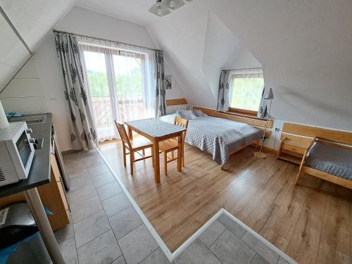 a bedroom with a bed and a table in a room at Przy Szlaku Zakopane centrum pokoje & apartamenty in Zakopane