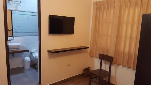 un bagno con un water e una televisione a parete di Hotel Tito ad Arequipa