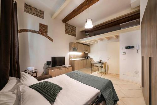 een slaapkamer met een bed en een kleine keuken bij Italianflat - La Vigna in Città in Verona